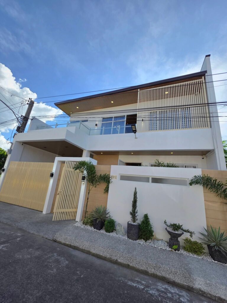 Front view of a furnished modern Scandinavian two-storey house for sale in Angeles City Pampanga near Marquee Mall with landscaped garden