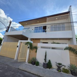 Front view of a furnished modern Scandinavian two-storey house for sale in Angeles City Pampanga near Marquee Mall with landscaped garden